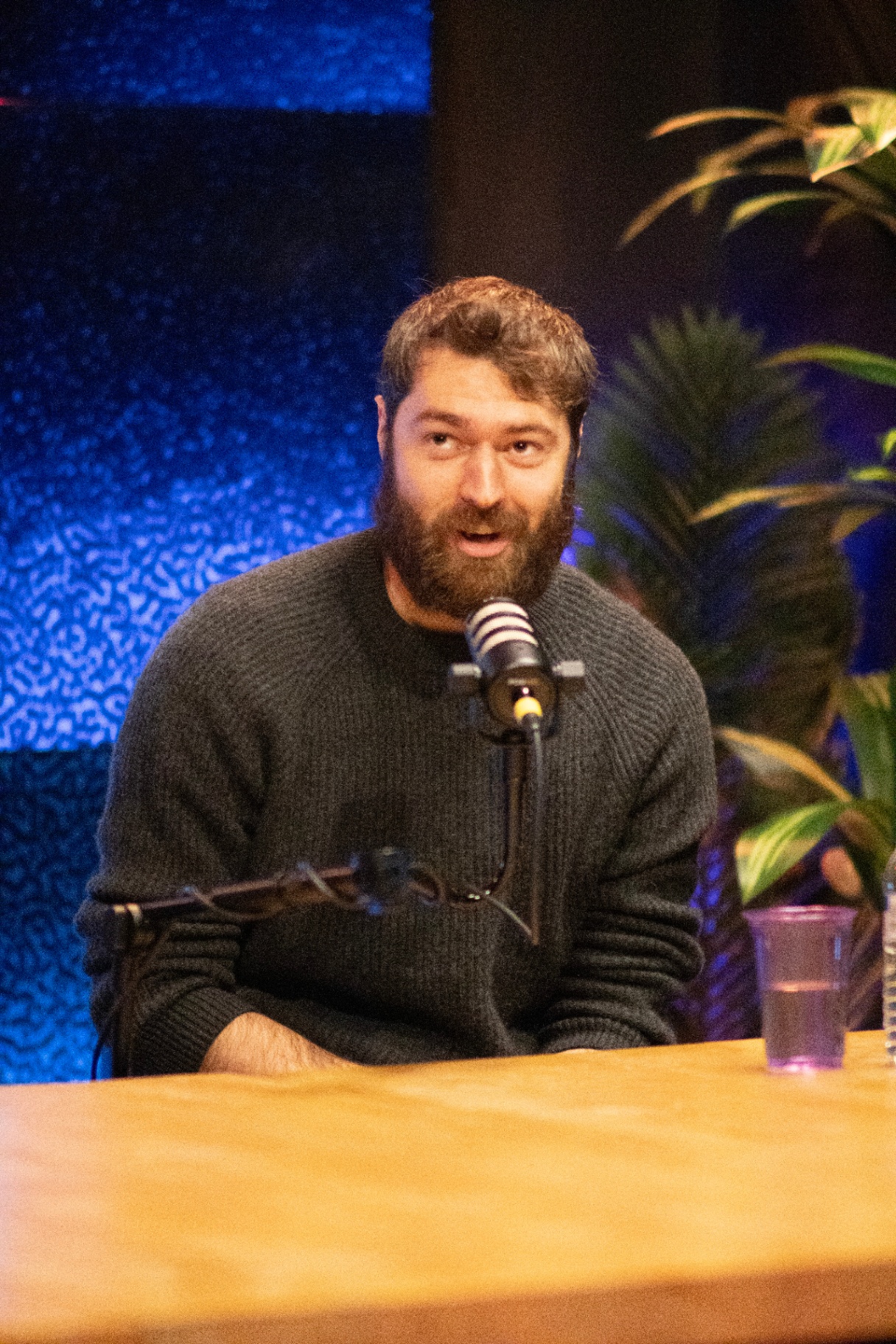 Podcast guest speaking into a studio microphone on a Click Stream Studios set